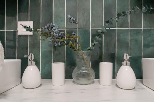 un vase avec des fleurs sur un comptoir avec des bougies dans l'établissement Cozy apartment near Paris Disney - 6 min from train station, à Villiers-sur-Marne