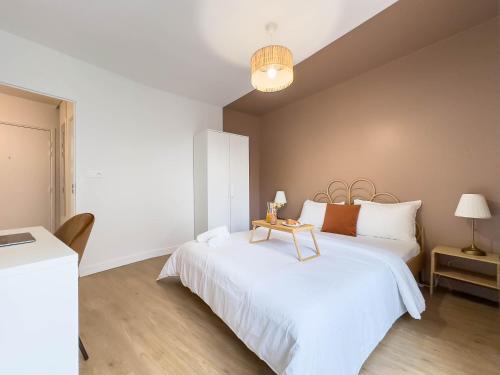 a bedroom with a white bed with a table on it at Cozy apartment near Paris Disney - 6 min from train station in Villiers-sur-Marne