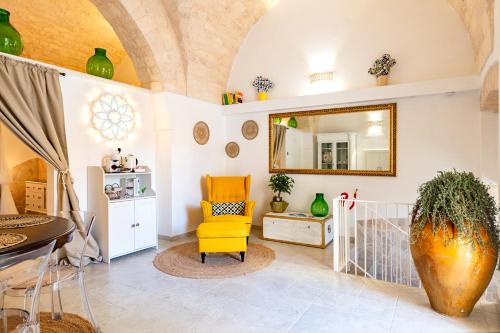 a living room with a yellow chair and a mirror at Un giorno bellissimo suite & spa in Martina Franca