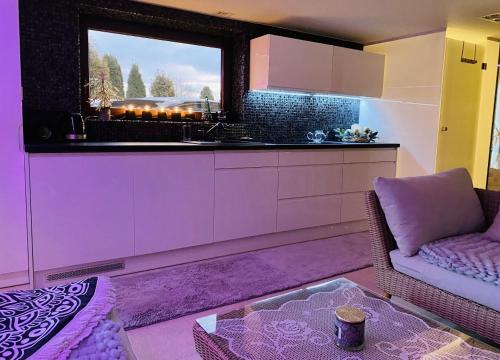 a living room with a kitchen with a window at DELUXE Dom z sauną i jacuzzi w otoczeniu gór, lasu i jeziora in Łodygowice