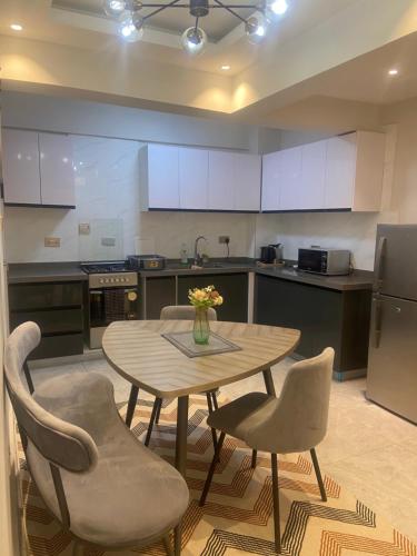 a kitchen with a table and chairs and a kitchen with white cabinets at 3 bedroom ensuite apartment Lavington in Nairobi