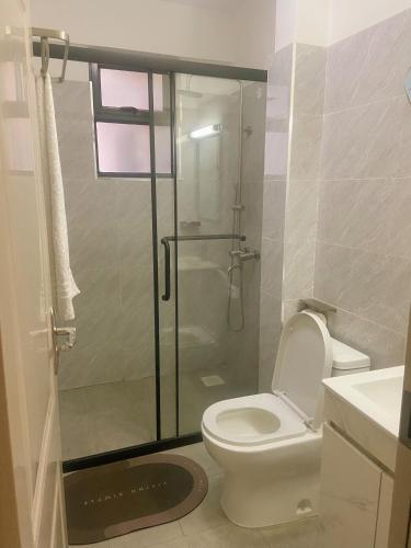 a bathroom with a toilet and a glass shower at 3 bedroom ensuite apartment Lavington in Nairobi