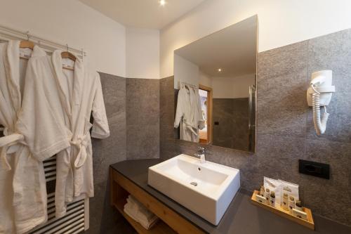 ein Bad mit einem Waschbecken und einem Spiegel in der Unterkunft Rifugio La Montanara in Molveno