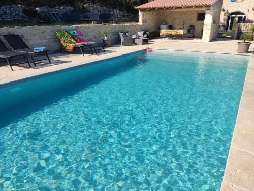 une piscine avec de l'eau bleue dans une cour dans l'établissement Beaux Yeux, à Montségur-sur-Lauzon