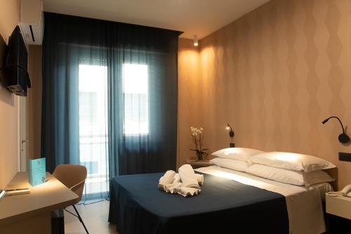 a bedroom with a bed with towels on it at Hotel Bolivar in San Benedetto del Tronto