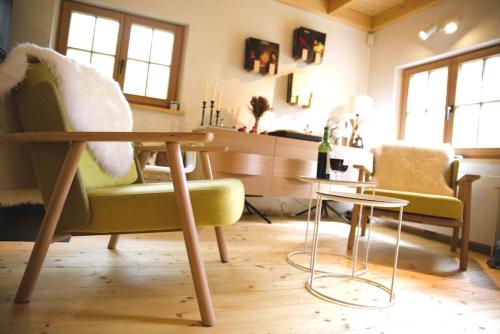 een woonkamer met 2 stoelen en een tafel bij Charming Chalet with River View in Michelau