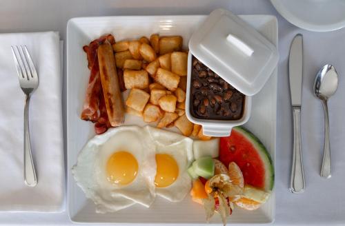 a plate of breakfast food with an egg and fruit at Chez Truchon Bistro-Auberge in La Malbaie