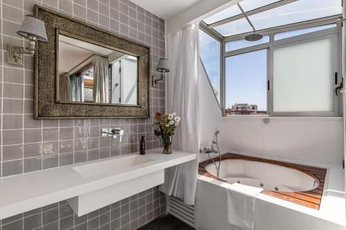 a bathroom with a tub and a window at BNBHolder Luxury Triplex CHAMBERI in Madrid