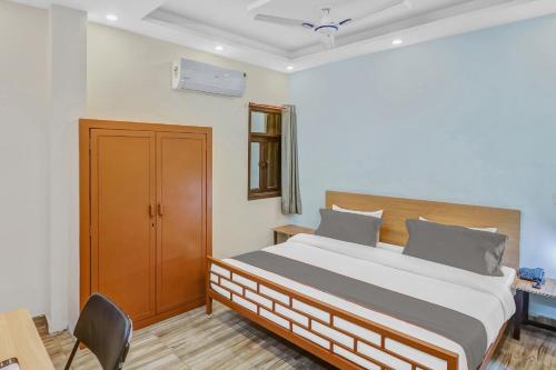 a bedroom with a bed and a chair in it at Capital O The Arrow Near Nawada Metro Station in New Delhi