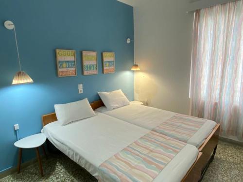 una camera con un grande letto con una parete blu di Thalia Hotel a Kamena Vourla