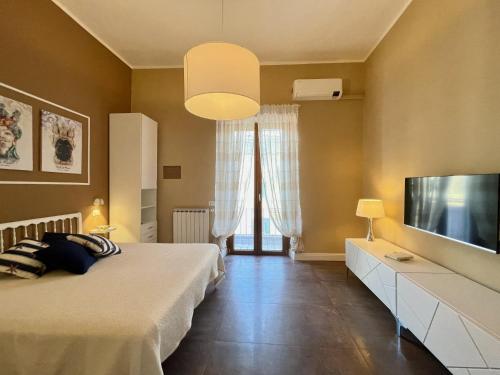 Schlafzimmer mit einem Bett und einem Flachbild-TV in der Unterkunft Casa Gramsci Anzio Centro in Anzio