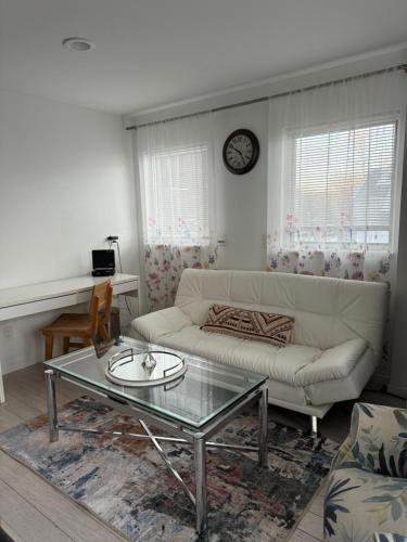 a living room with a white couch and a glass table at One bedroom with modern kitchen, balcony with water view in Greenwich