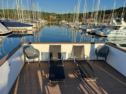 a deck with chairs and boats in a marina at Sunset Joy in Portorož