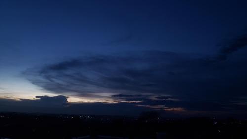 a cloudy sky at dusk with a city at Kindiha homes. in Seeta