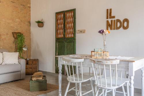 sala de estar con mesa, sillas y puerta en Il Nido, en Buonconvento