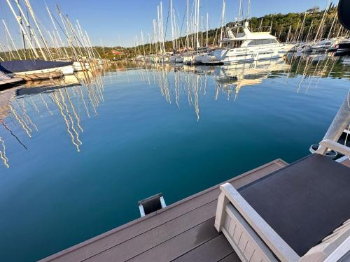 a chair sitting on a dock in a marina with boats at Sunset Joy in Portorož
