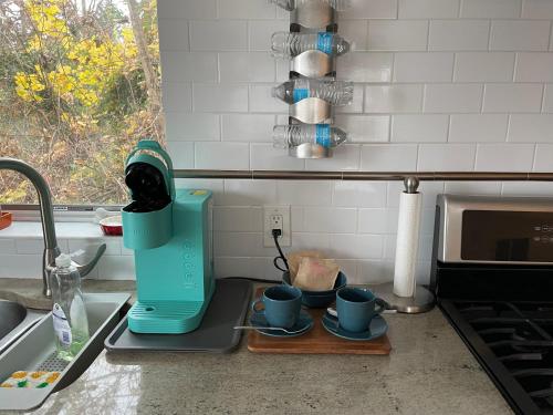 a kitchen counter with a coffee maker and two cups at One bedroom with modern kitchen, balcony with water view in Greenwich
