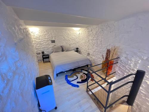 une chambre avec un lit et un mur dans l'établissement La maisonnette - Atypique / Tout équipé !, à Nîmes