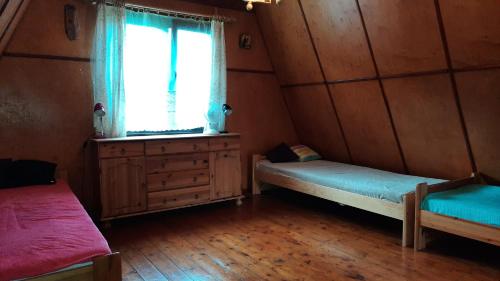 a small room with two beds and a window at Klimatyczny domek z łodką nad jeziorem in Dobre Miasto