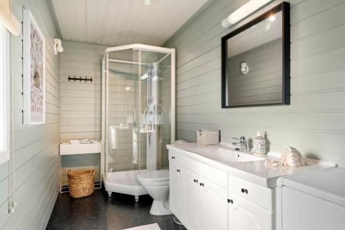 La salle de bains est pourvue d'une douche, de toilettes et d'un lavabo. dans l'établissement Sjarmerende hytte nær sjøen - 4 soverom, à Strand