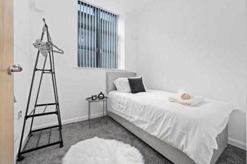 a bedroom with a bed with a tripod next to a window at Modern 2Bed Northern Quarter, Long Stays, Contractors in Manchester