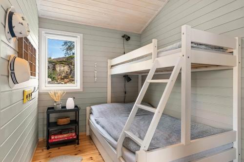 a bunk bed in a tiny house at Sjarmerende hytte nær sjøen - 4 soverom in Strand