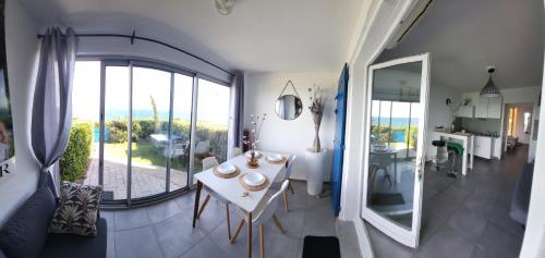 un salon avec une table et une grande fenêtre dans l'établissement BLEU BOUCHAREL, à Saint-Aygulf