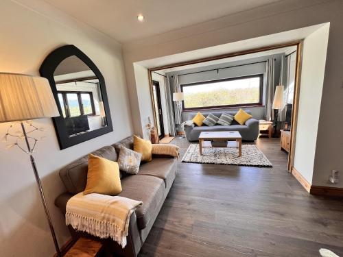 a living room with a couch and a table at Detached 3 Bed Cottage Mountain Views- Pets Wifi in Beaumaris