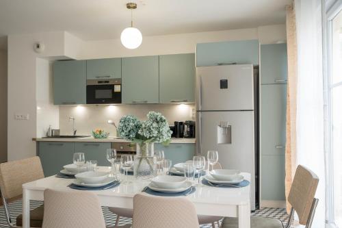 une salle à manger avec une table blanche et un réfrigérateur blanc dans l'établissement Cozy apartment near Paris Disney - 6 min from train station, à Villiers-sur-Marne