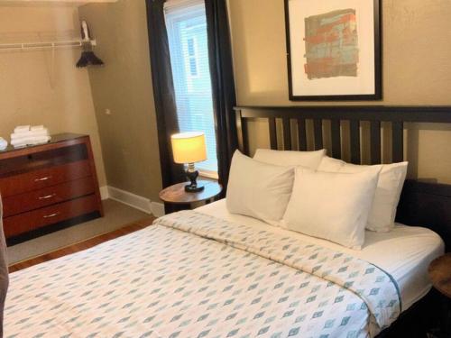 sypialnia z łóżkiem z białymi poduszkami i lampą w obiekcie The House Hotels- Lark #4 - Centrally Located in Lakewood - 10 Minutes to Downtown Attractions w mieście Lakewood