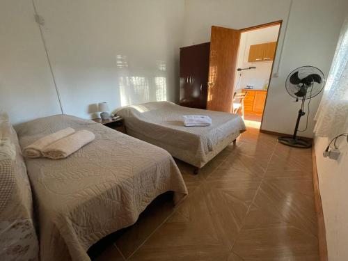 um quarto de hotel com duas camas e uma ventoinha em Cómodo apartamento en Minas, con amplio fondo y entrada para vehículo em Minas