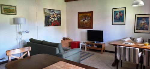 a living room with a couch and a tv at Casa Cicala in Trarego