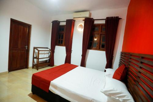 a bedroom with a bed and a chair in it at Stellar Inn in Peradeniya
