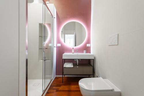 un bagno con un water, un lavandino e uno specchio di Mecenate Suite Colosseum a Roma