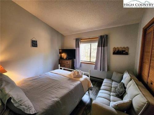 a bedroom with a bed and a couch at Cozy Cabin Walkable to Beech Mt Resort in Beech Mountain