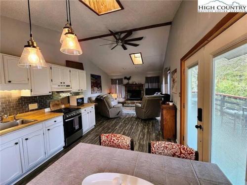 a kitchen with white cabinets and a ceiling fan at Cozy Cabin Walkable to Beech Mt Resort in Beech Mountain