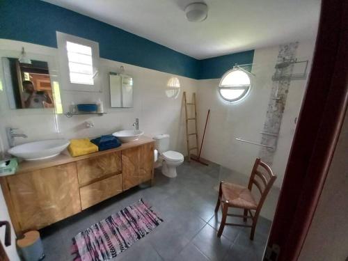 La salle de bains est pourvue de 2 lavabos, de toilettes et d'un miroir. dans l'établissement Gîte chez Rémisa, à Petit-Bourg