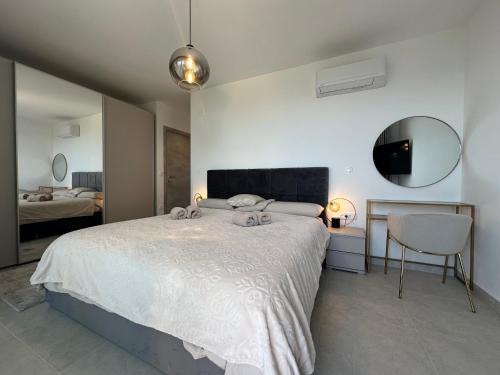 a bedroom with a large bed and a mirror at Villa Allure Sensuelle with heated pool - New 2024! in Kaštela