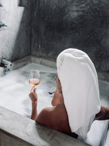 a woman sitting in a bath tub with a glass of wine at Residencia Tropical Don Bonito in Sayulita
