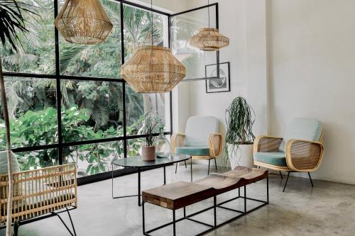 uma sala de estar com uma mesa, cadeiras e janelas em Residencia Tropical Don Bonito em Sayulita