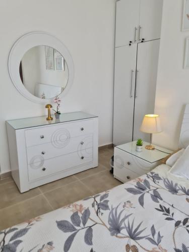 a bedroom with a white dresser and a mirror at Sahel 3BR chalet Mountian view North coast Ras Elhekma in Zāwiyat al ‘Awwāmah