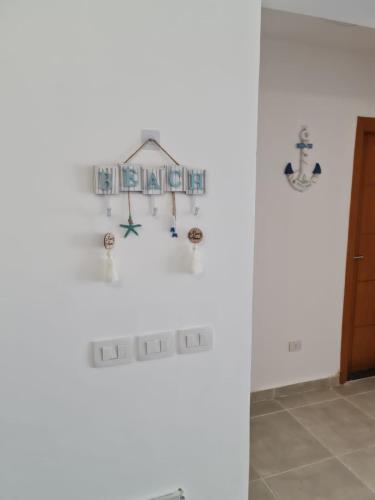 a room with a white wall with signs on the wall at Sahel 3BR chalet Mountian view North coast Ras Elhekma in Zāwiyat al ‘Awwāmah