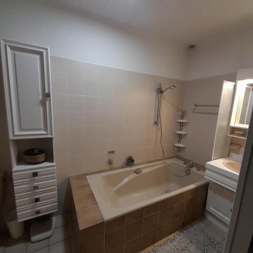 une salle de bain blanche avec une baignoire et un lavabo dans l'établissement Gites des menhirs, à Camaret-sur-Mer