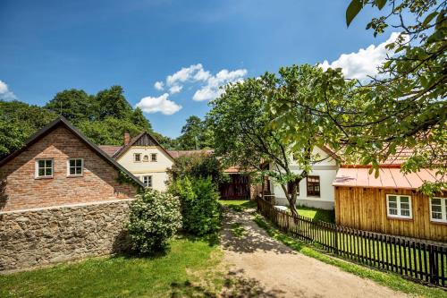 a house with a stone wall and a fence at Chalupa u rybníka pod Blaníkem in Postupice