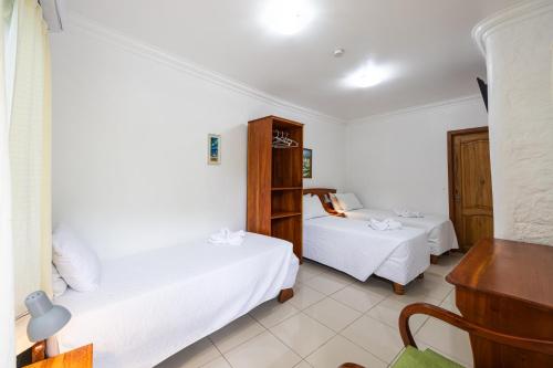 a bedroom with two beds and a desk at La Peregrina Galapagos B&B in Puerto Ayora