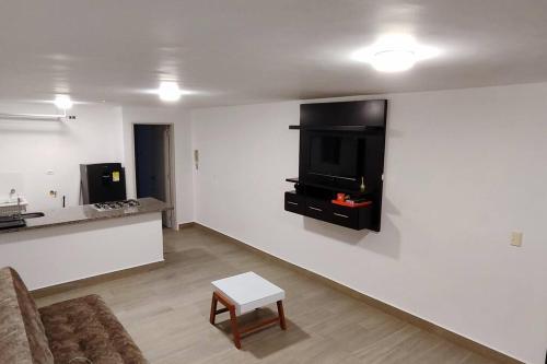 ein Wohnzimmer mit einem Sofa und einem Fernseher an der Wand in der Unterkunft San Gil Aparta estudio hermosa vista in San Gil