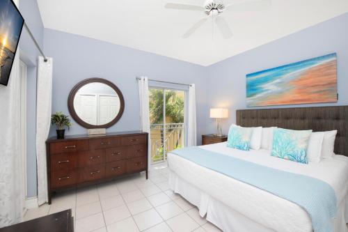 a bedroom with a large bed and a mirror at Regal Beach Club #533 in George Town