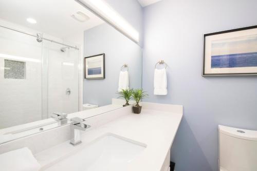 a white bathroom with a sink and a mirror at Regal Beach Club #533 in George Town