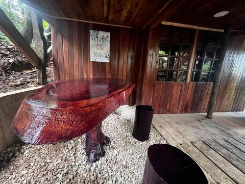 a large red bowl sitting on a wooden floor at Refugio del Bosque CABAÑAS Y GLAMPING in Guácimo