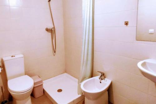 Baño blanco con aseo y lavamanos en Apartamento nuevo en el centro de Gandía, en Gandía